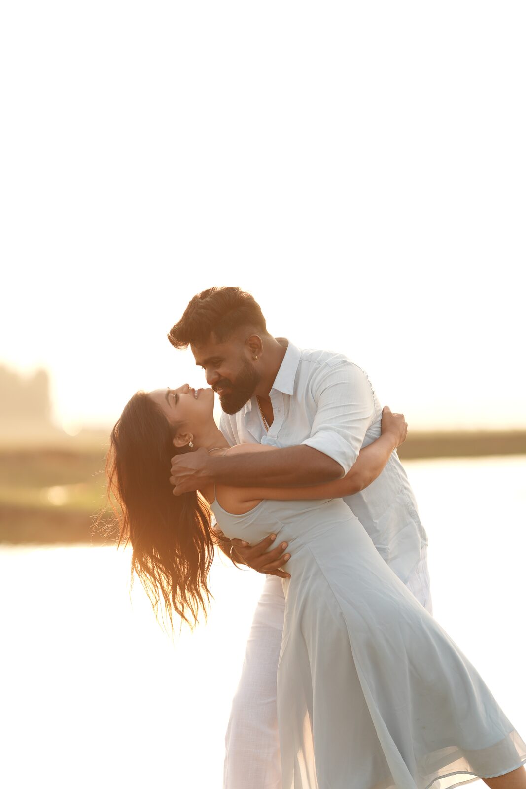Karthik and Deeksha in an embrace at sunset by the water