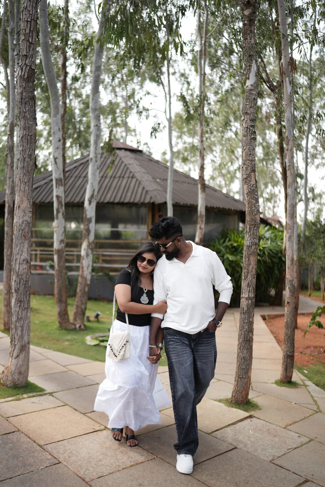 Karthik and Deeksha walking under tall trees